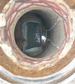 Manhole during preparation, with leaks marked and corrosion exposed