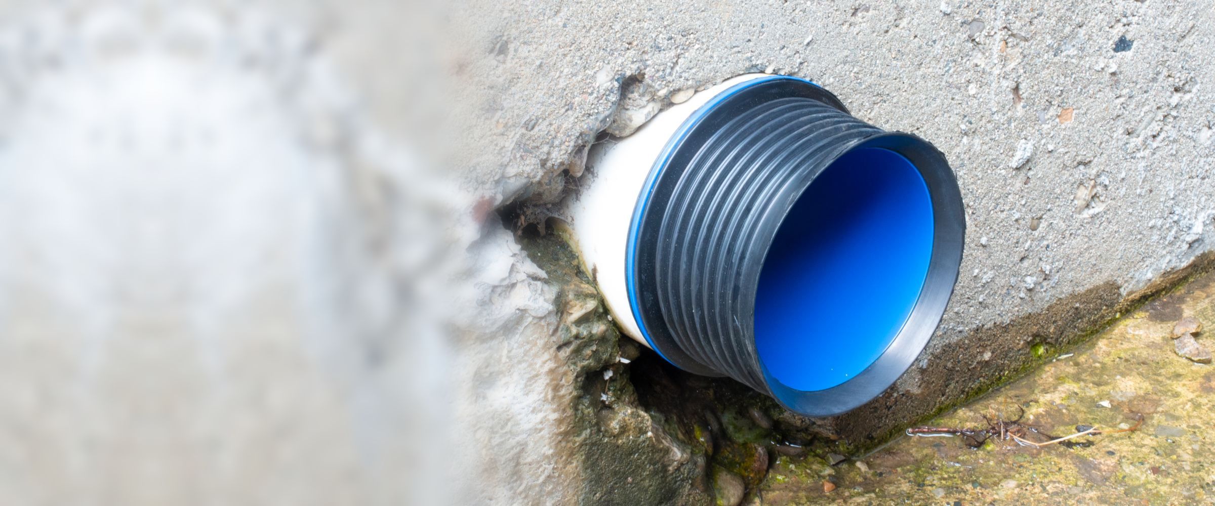 Fernco ICON Pushfit coupling pushed into a pipe stub coming out of a concrete foundation wall