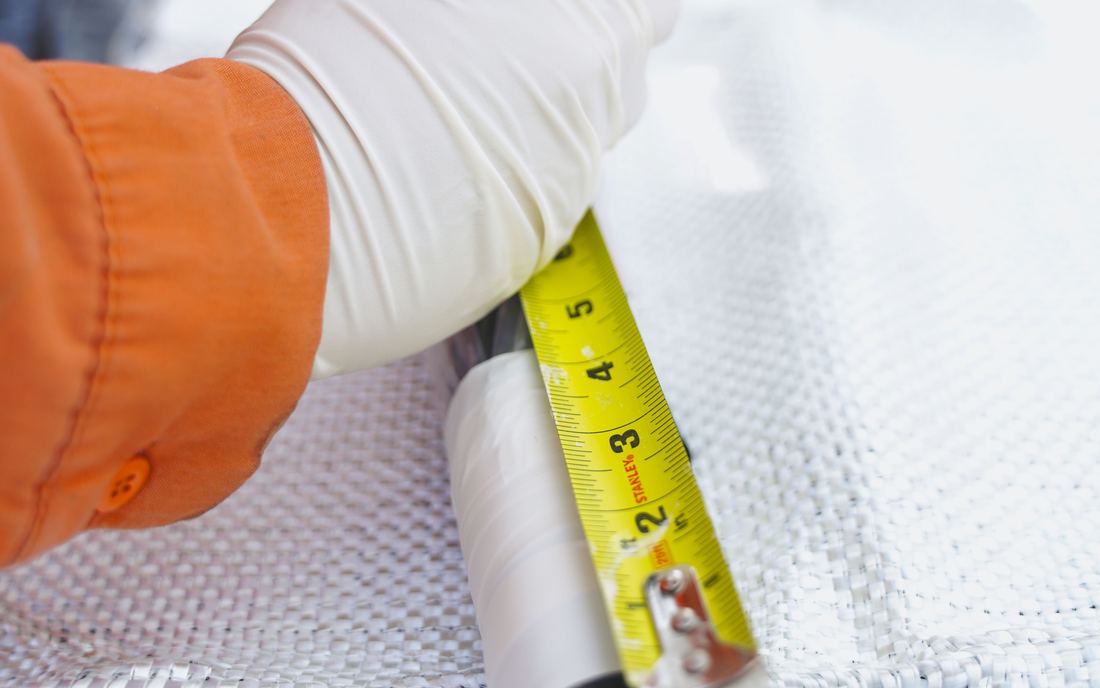 A tape measure laid along the fiberglass mat