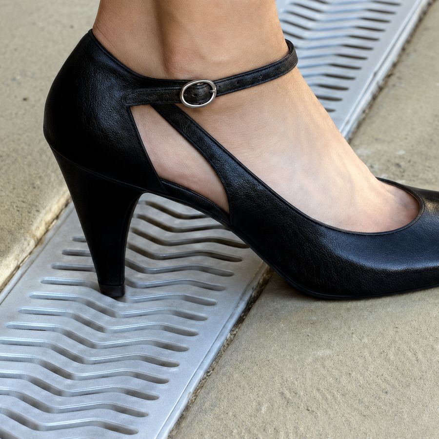 A high heel resting on the StormDrain Plus grate without slipping into the slots
