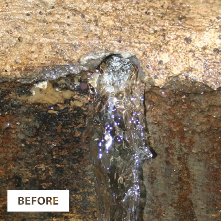 Water running from a leaking joint in a concrete chamber wall