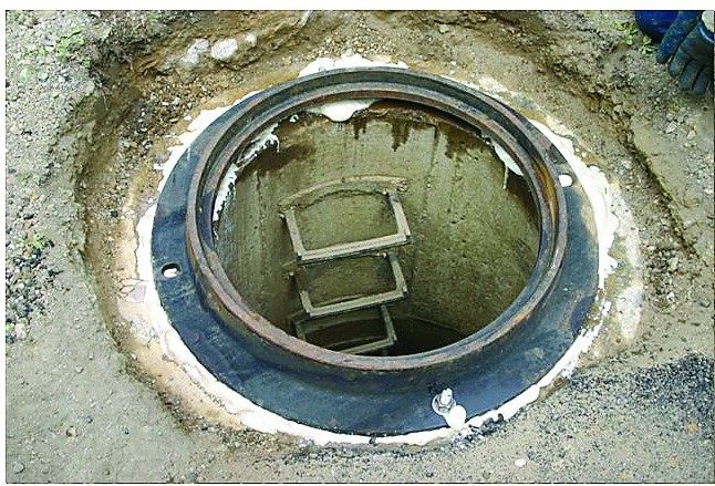 A newly set manhole frame with cured X-Seal visible around the joint