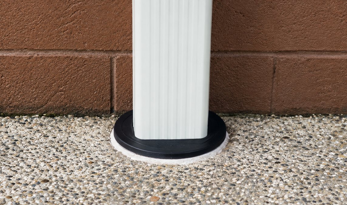 Fernco UDSC-6P plug set into a 6 inch pipe cut off at grade, with a white downspout through the top